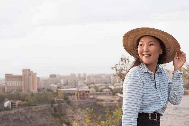 Giovane donna asiatica in cappello all'aperto in estate