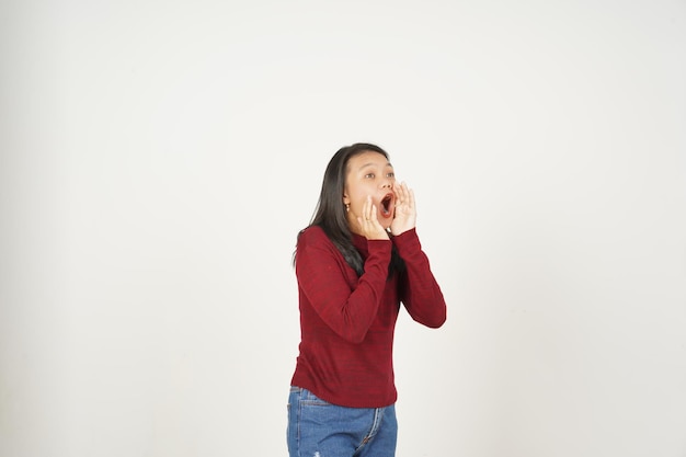 Giovane donna asiatica in maglietta rossa grida pubblicità isolata su sfondo bianco