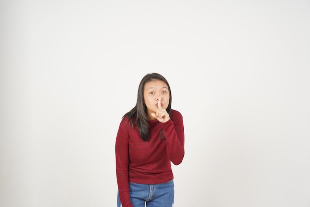 Giovane donna asiatica in maglietta rossa Silenziosa Shh Non essere rumore isolato su sfondo bianco
