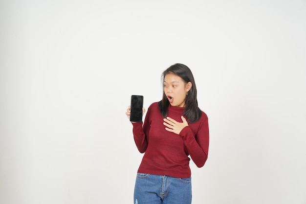 Giovane donna asiatica in maglietta rossa Wow scioccata e mostra lo schermo vuoto dello smartphone isolato su sfondo bianco