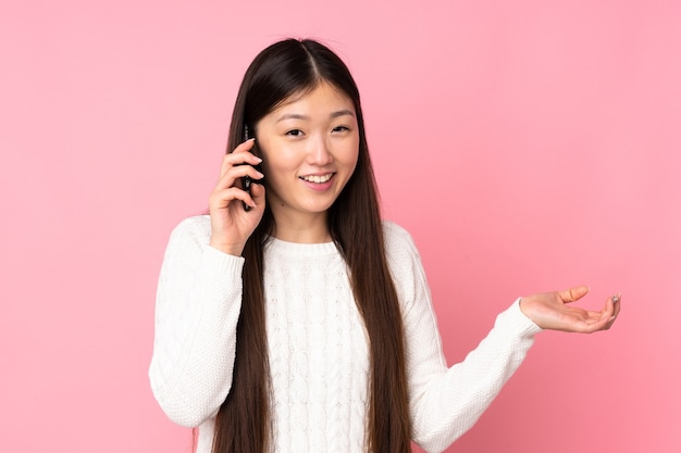 Giovane donna asiatica più isolata mantenendo una conversazione con il telefono cellulare