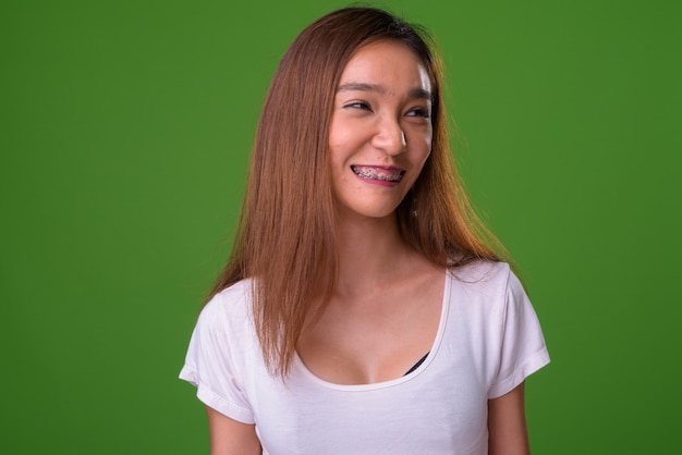 Giovane donna asiatica sottile su sfondo verde