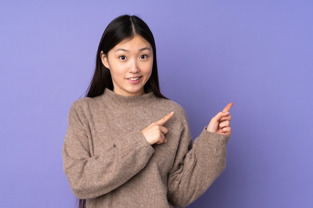 Giovane donna asiatica spaventata e indicando il lato