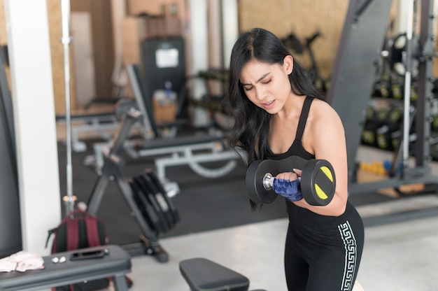 Giovane donna asiatica sportiva con il dumbbell