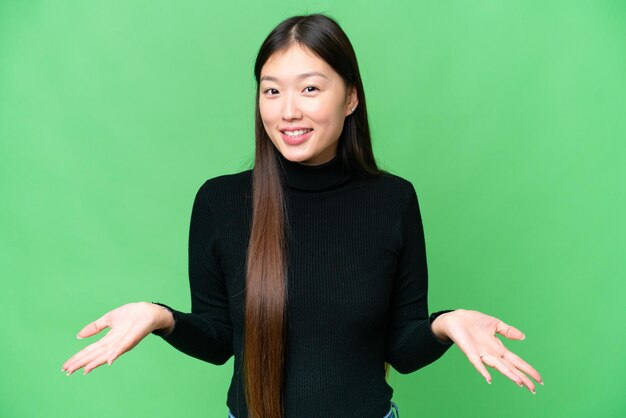 Giovane donna asiatica su sfondo chroma key isolato felice e sorridente
