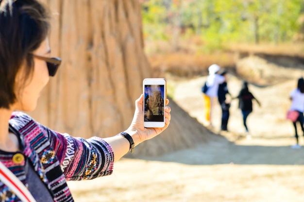 Giovane donna asiatica Usa lo smart phone per scattare foto in vacanza.