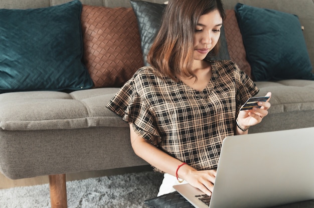 Giovane donna asiatica utilizzando la carta di credito per lo shopping online