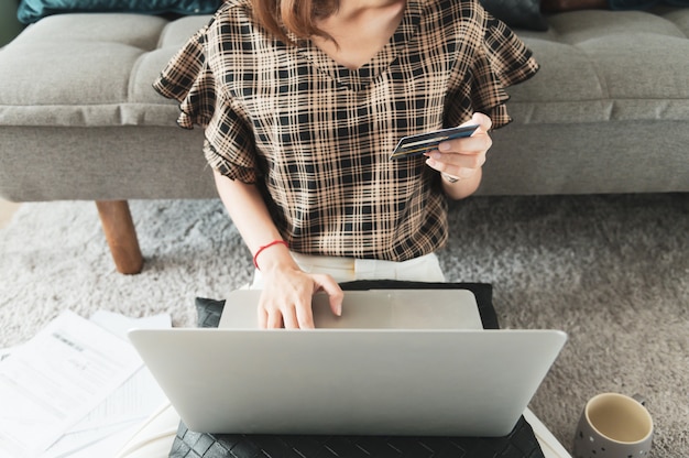 Giovane donna asiatica utilizzando la carta di credito per lo shopping online