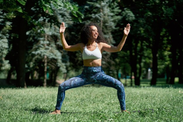 Giovane donna atletica che esegue ginnastica mattutina all'aperto