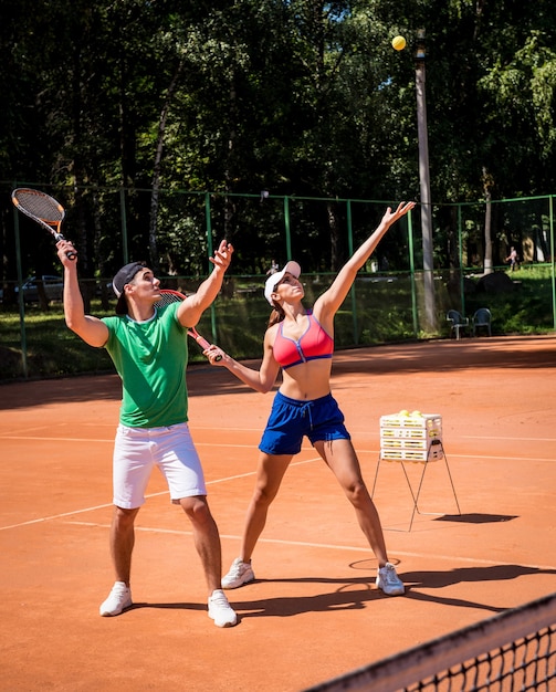 Giovane donna atletica che gioca a tennis con il suo allenatore