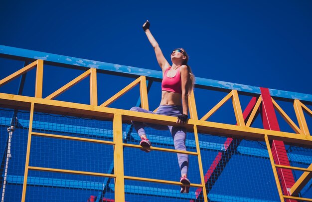Giovane donna atletica che si allena e si arrampica al campo di addestramento