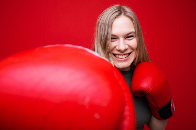 Giovane donna atletica in guanti da boxe rossi in allenamento