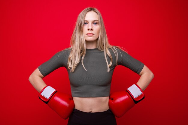 Giovane donna atletica in guantoni da boxe rossi in formazione