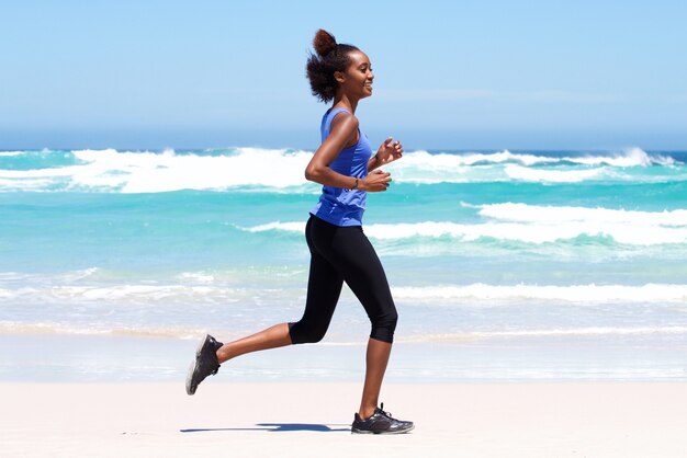 Giovane donna attiva che corre all&#39;aperto