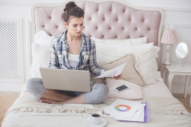 Giovane donna attraente che lavora al computer portatile