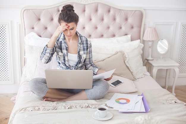 Giovane donna attraente che lavora al computer portatile