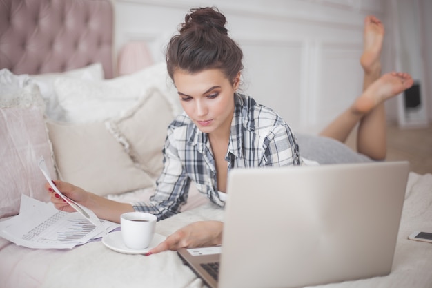 Giovane donna attraente che lavora al computer portatile