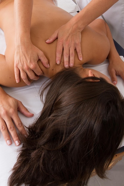 Giovane donna attraente che riceve massaggio alla schiena al centro termale