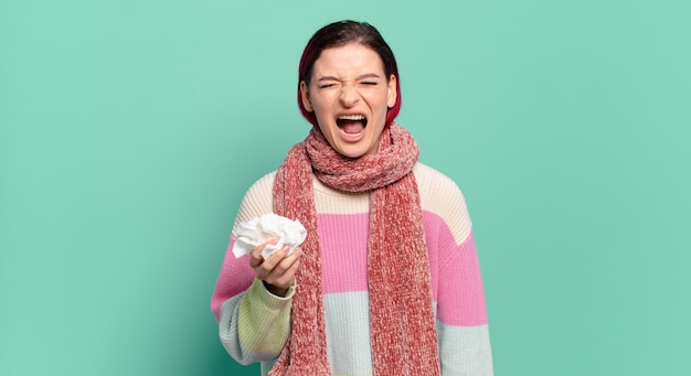 Giovane donna attraente con i capelli rossi che grida in modo aggressivo, sembra molto arrabbiata, frustrata, oltraggiata o infastidita, urlando nessun concetto di influenza