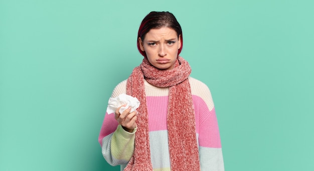 Giovane donna attraente con i capelli rossi che si sente triste e piagnucolona con uno sguardo infelice, piangendo con un concetto di influenza di atteggiamento negativo e frustrato