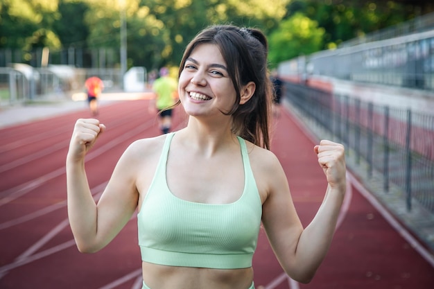 Giovane donna attraente in abiti sportivi che pareggiano allo stadio