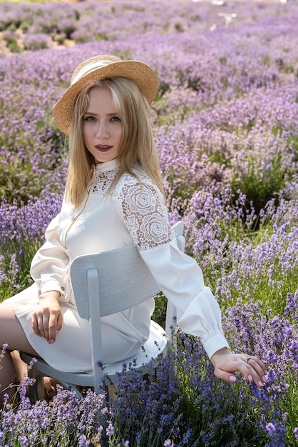 Giovane donna attraente in cappello con fiori di lavanda