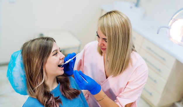 Giovane donna attraente in clinica di stomatologia con dentista femminile allegro Concetto di denti sani