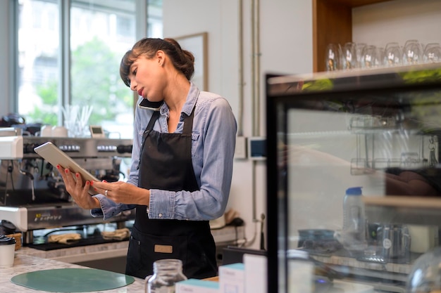 Giovane donna barista orientata al servizio che lavora nella caffetteria