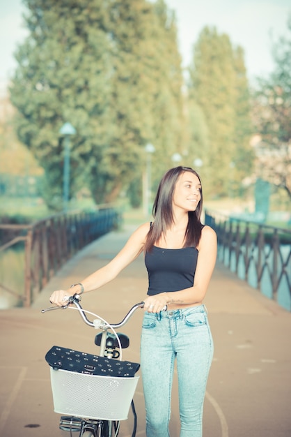 giovane donna bella bruna capelli lisci con bici