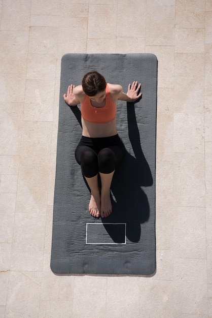 giovane donna bella che fa esercizi di yoga mattutini davanti alla sua vista dall'alto della sua villa di lusso