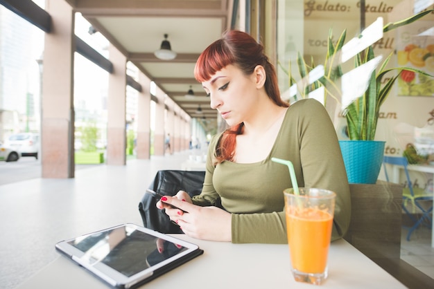 giovane donna bella rossa utilizzando smartphone