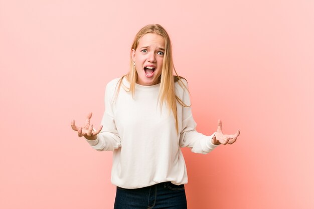 Giovane donna bionda adolescente che grida di rabbia.