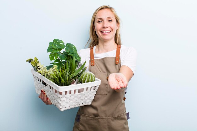 Giovane donna bionda adulta che fa giardinaggio con le piante