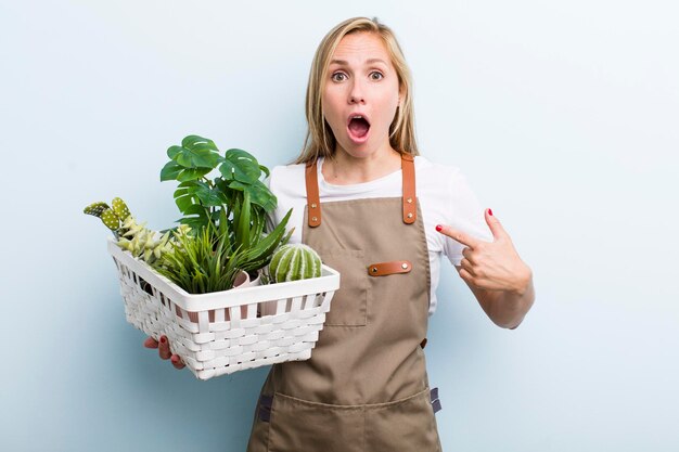 Giovane donna bionda adulta che fa giardinaggio con le piante