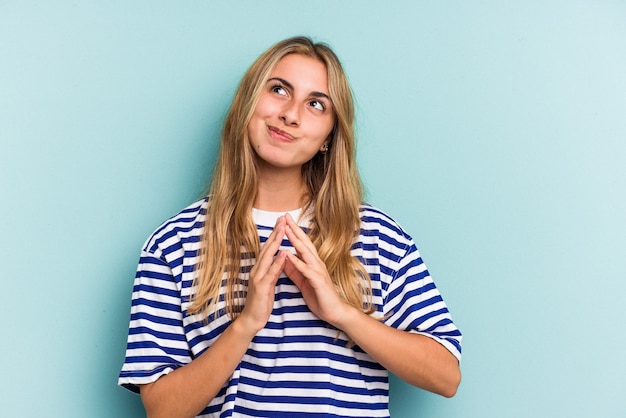 Giovane donna bionda caucasica isolata su sfondo blu che compongono il piano in mente, la creazione di un'idea.