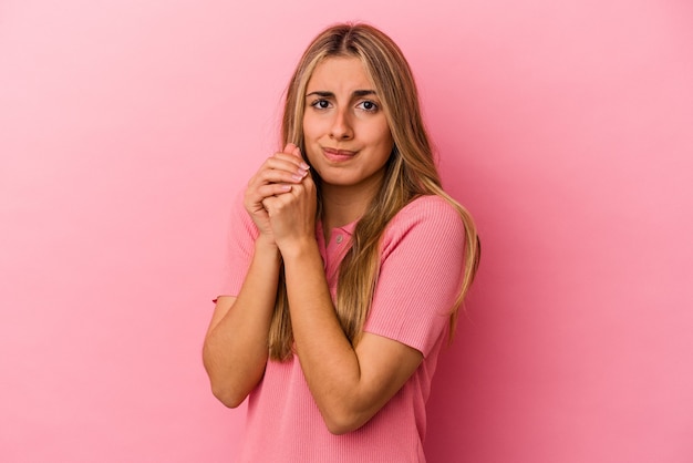 Giovane donna bionda caucasica isolata sulla parete rosa spaventata e impaurita