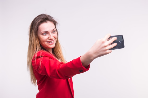 Giovane donna bionda che fa selfie in studio