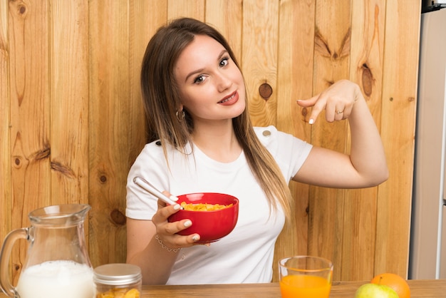 Giovane donna bionda che mangia prima colazione