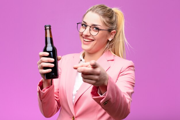 Giovane donna bionda che mangia una birra