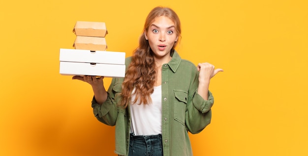 Giovane donna bionda che porta via gli alimenti a rapida preparazione