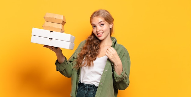 Giovane donna bionda che porta via gli alimenti a rapida preparazione