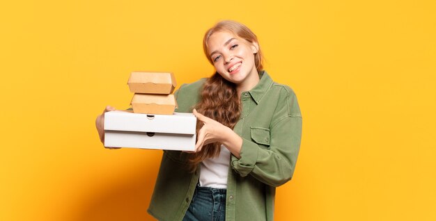 Giovane donna bionda che porta via gli alimenti a rapida preparazione