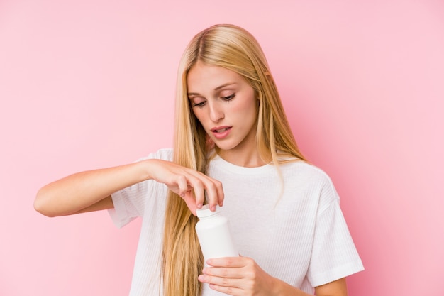 Giovane donna bionda che prende alcune pillole