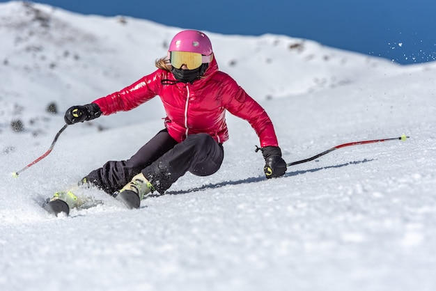 Giovane donna bionda che scia in una giornata di sole.