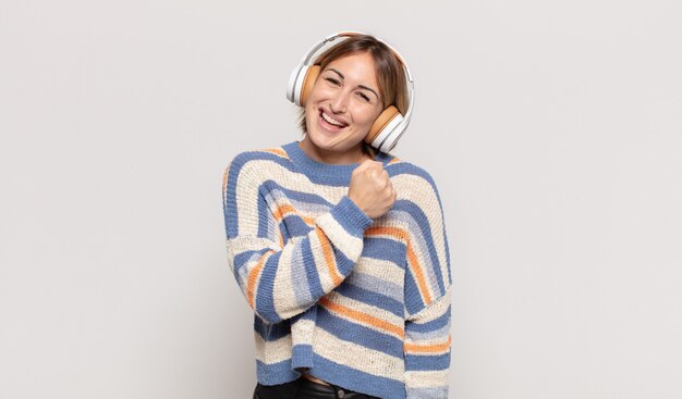 Giovane donna bionda che si sente felice, positiva e di successo, motivata quando affronta una sfida o celebra buoni risultati