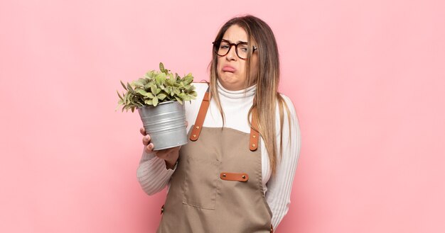 Giovane donna bionda che si sente triste e piagnucolona con uno sguardo infelice, piangendo con un atteggiamento negativo e frustrato