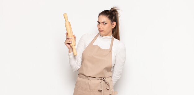 Giovane donna bionda che si sente triste, sconvolta o arrabbiata e guarda di lato con un atteggiamento negativo, accigliata in disaccordo