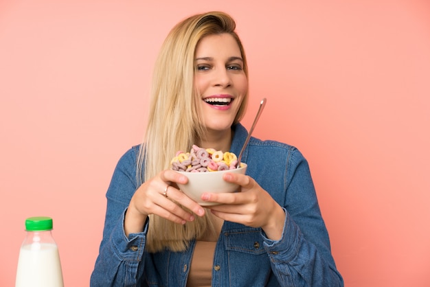 Giovane donna bionda con ciotola di cereali