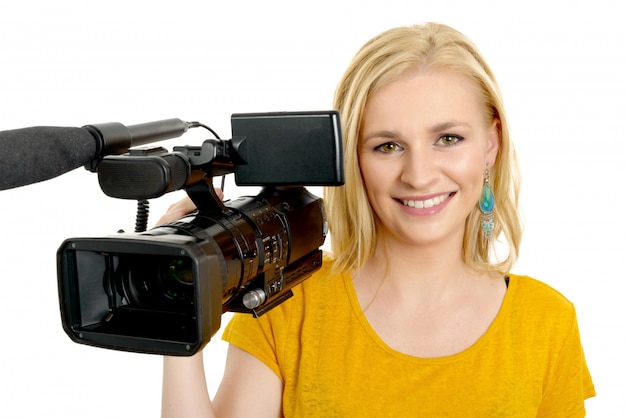 Giovane donna bionda con la videocamera portatile professionale, su bianco