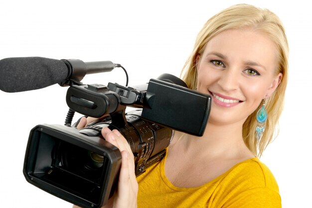 Giovane donna bionda con la videocamera professionale, su bianco